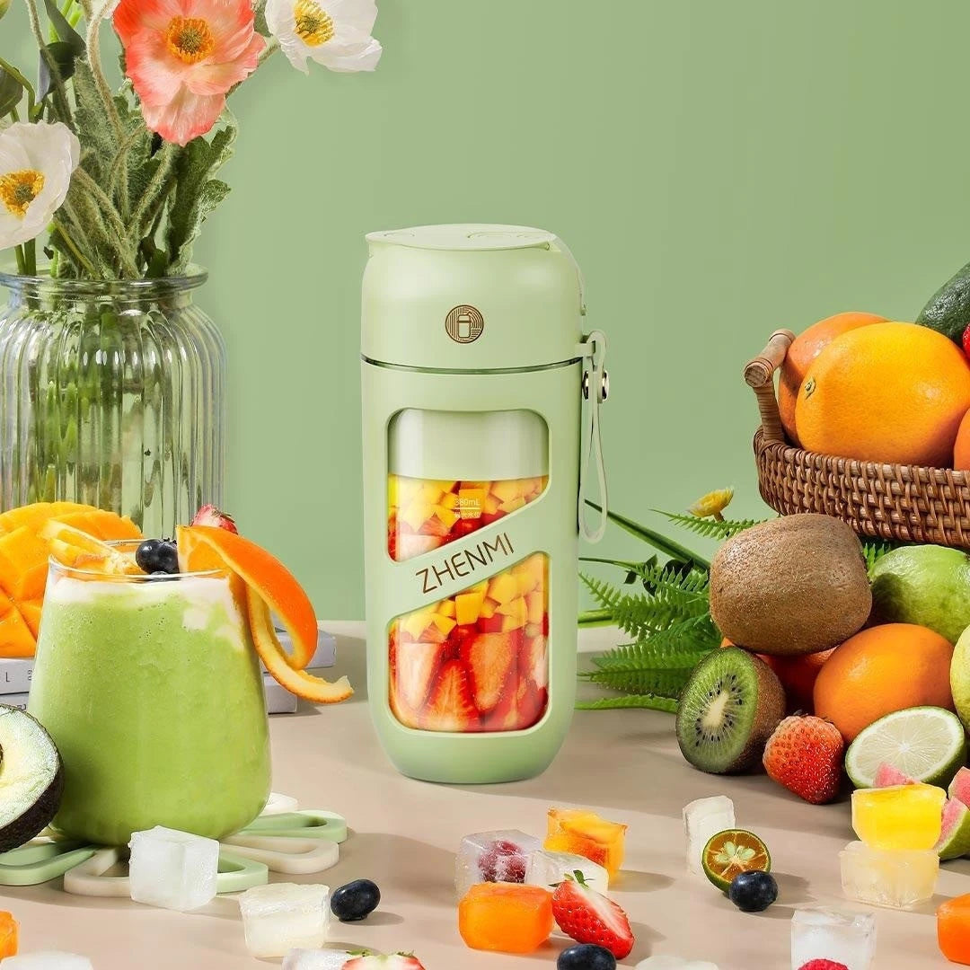 Green portable blender filled with fresh fruit, surrounded by a smoothie and vibrant fruits. Perfect for on-the-go blending and healthy drinks.